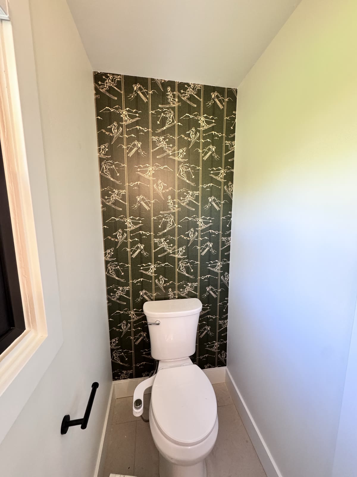 Ski-pattern wallpaper installed behind a toilet